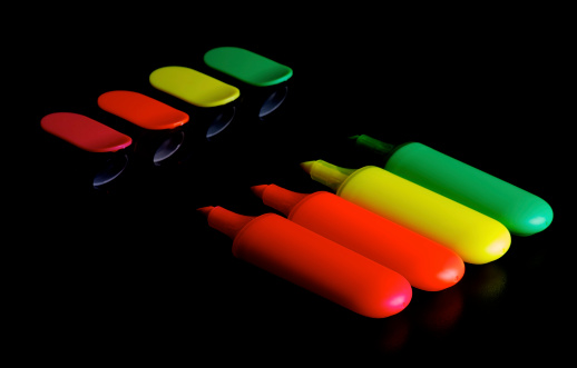 Red, Orange, Yellow and Green Fluorescent Highlighter Pens with Caps isolated on black background