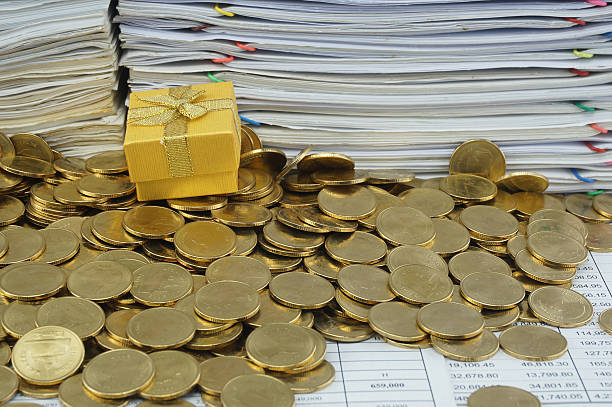istock Gift box in heap of gold coins 470607020