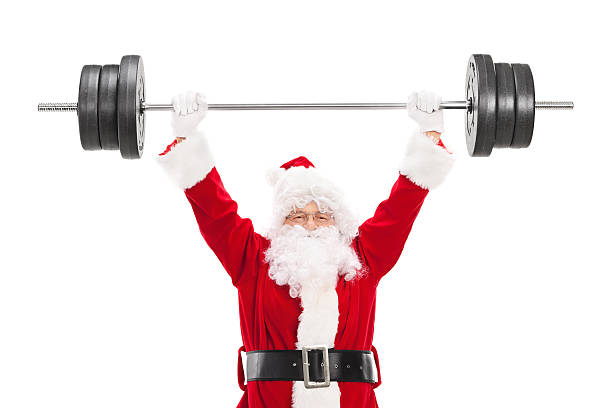 Smiling Santa Claus lifting a heavy barbell and looking at camera isolated on white background