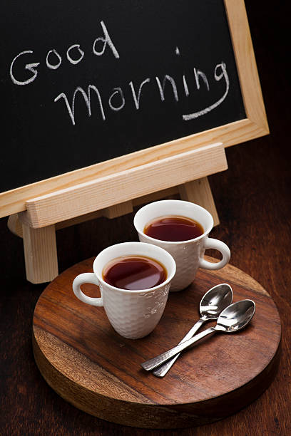 Good Morning chalk writing. Cups of tea and brushes stock photo