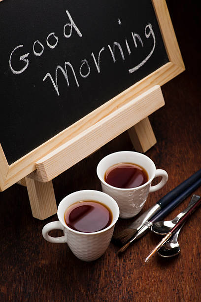 Good Morning chalk writing. Cups of tea and brushes stock photo