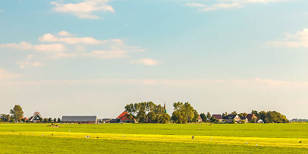 Farm land and small Dutch village in the Friesland province Panoramic view of a small Dutch village in the province of Friesland friesland netherlands stock pictures, royalty-free photos & images