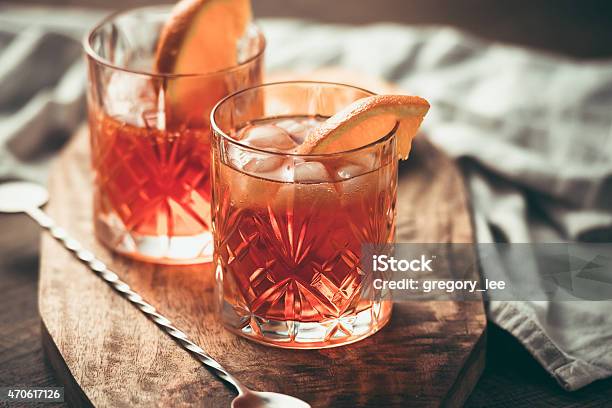 Two Cocktails Garnished With Orange Slices On Wooden Bar Top Stock Photo - Download Image Now