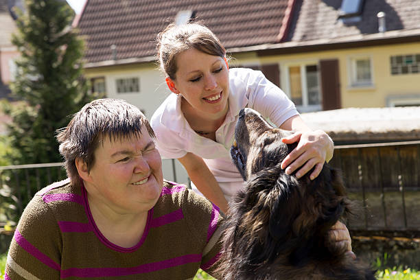 istock two woman stroking a dog 470618410