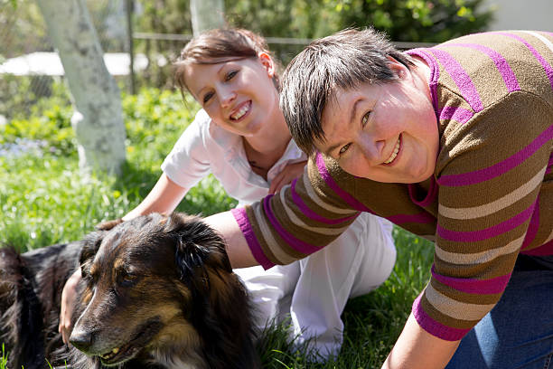two women and a half breed dog