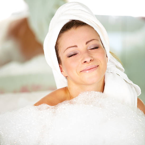 istock Relaxed and smiling young woman lying in a bath 470619259