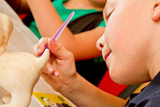 istock 8 Year Old Caucasian Boy Painting Pottery 470622222