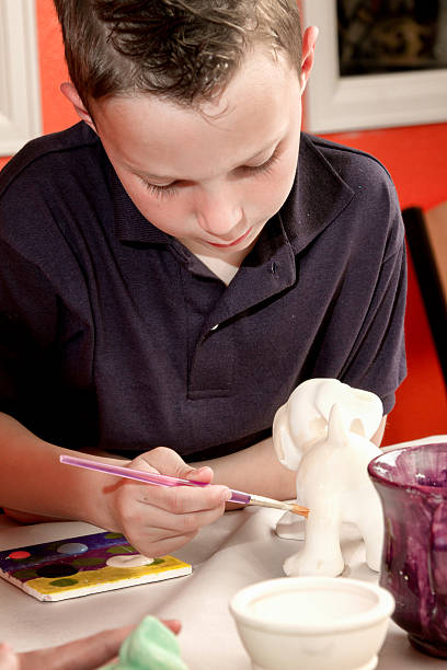 istock 8 Year Old Caucasian Boy Painting Pottery 470622230