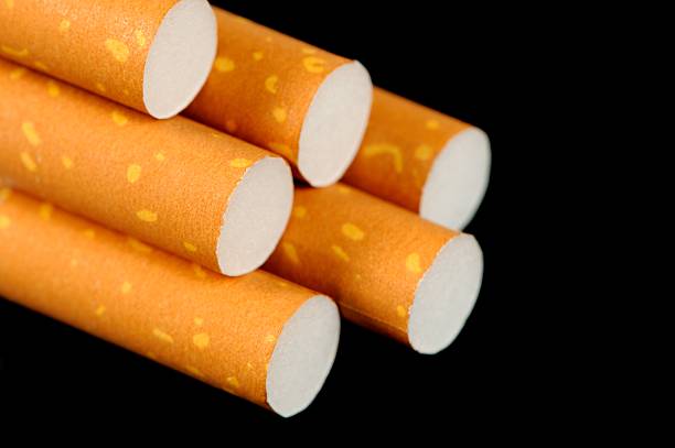istock Cigarettes with Yellow Filters on Black Background 470622373
