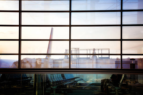 istock Airport gate with plane boarding shot through glass at sunset 470623250