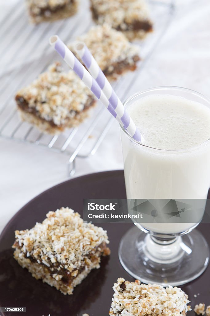 Raw Vegan Date Squares Raw vegan date squares made with brazil nuts and a cup of almond milk with two straws. Date - Fruit Stock Photo