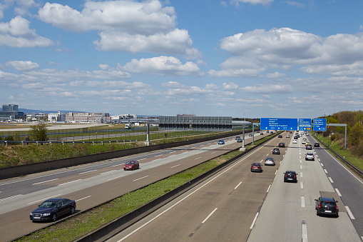 Frankfurt, Germany - April 18, 2015: The federal Autobahn A5 beneath the Airport of Frankfurt (Germany) in direction to the Frankfurt Kreuz with a road sign to the airport taken on April 18, 2015. All recognizeable number plates are retouched.