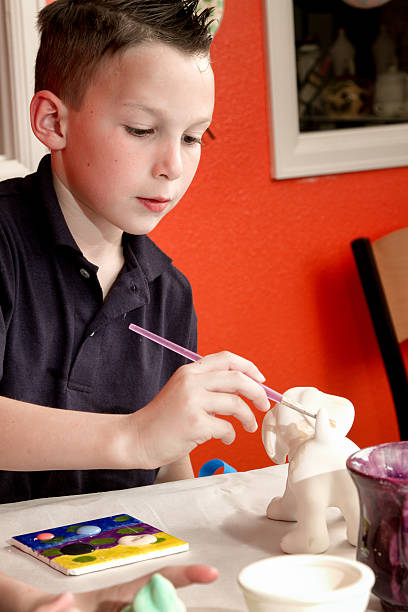 istock 8 Year Old Caucasian Boy Painting Pottery 470633652
