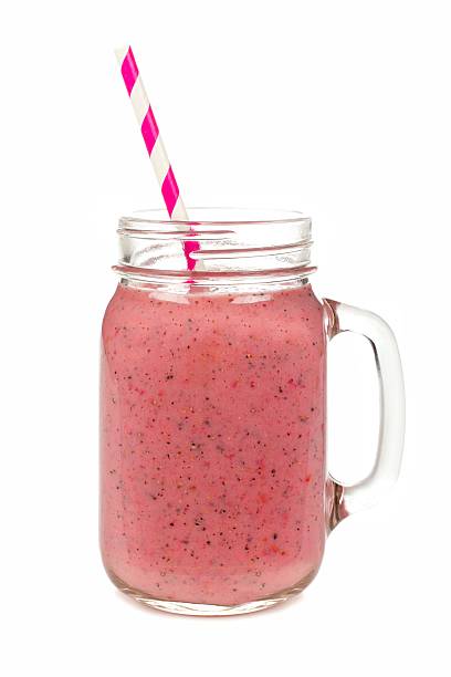 istock Pink fruit smoothie in mason jar glass isolated on white 470638934