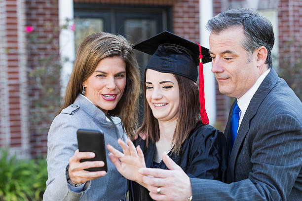 istock Family at graduation looking at mobile phone 470640730