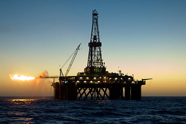 istock Ocean oil rig silhouette at sunset. 470640846