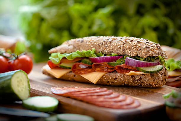 sabrosos sándwiches en una mesa de madera - sandwich turkey gourmet fast food fotografías e imágenes de stock