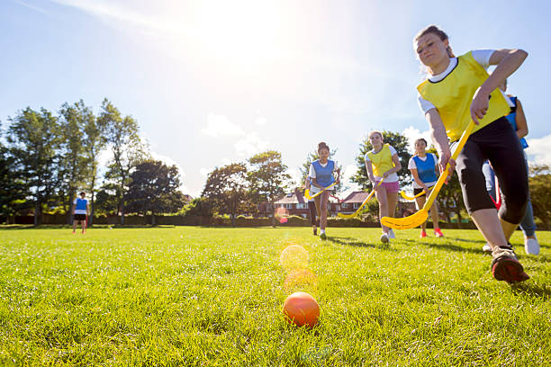 "I've got this one in the bag!" Low angle view shot of a young teenage girl going in to tackle away a hockey ball while being chased by her team mates and other competitors. field hockey stock pictures, royalty-free photos & images