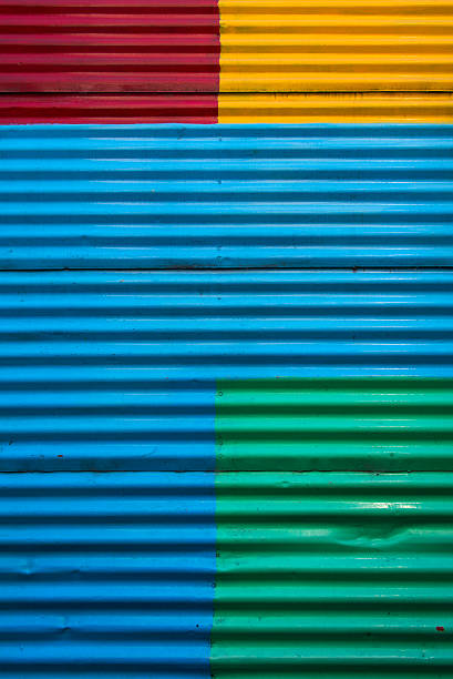 Colorful and full frame background image of a corrugated wall in La Boca district, Buenos Aires. The wall is painted in blue, yellow, red and green.