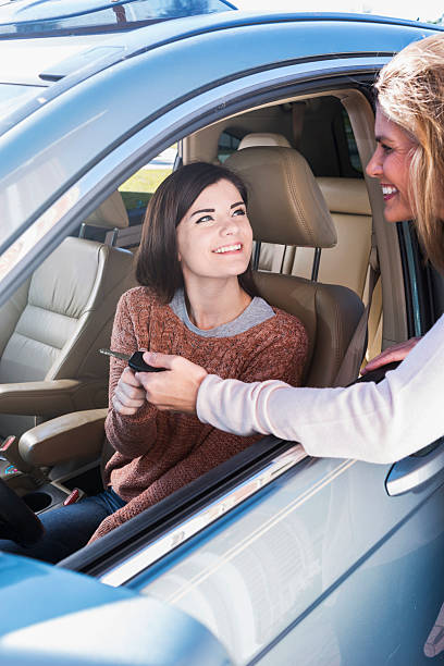 istock Mother giving daughter key to  car 470643714