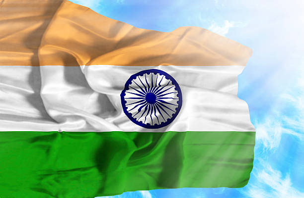 istock India waving flag against blue sky with sunrays 470647131