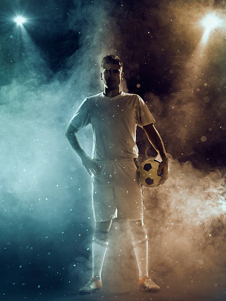 istock Soccer player with ball standing under two-color spotlights 470647618
