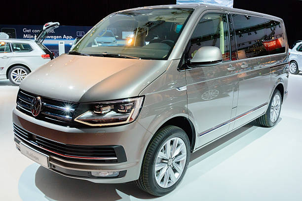Amsterdam, The Netherlands - April 16, 2015: Volkswagen Transporter T6 Multivan people carrier on display during the 2015 Amsterdam motor show. People in the background are looking at the cars.