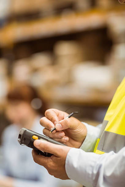 istock Close up of manager wearing yellow vest using handheld 470650654