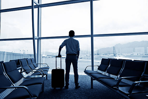 istock Man with hand luggage staring at airport movement 470651374