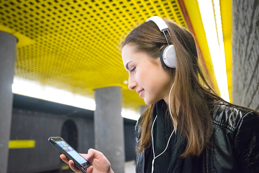 Beautiful Woman Listening Music On Her Smartphone, Subway Station