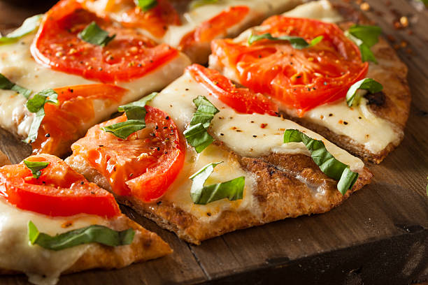 Homemade thin crust pizza with tomato topping Homemade Margarita Flatbread Pizza with Tomato and Basil flatbread photos stock pictures, royalty-free photos & images
