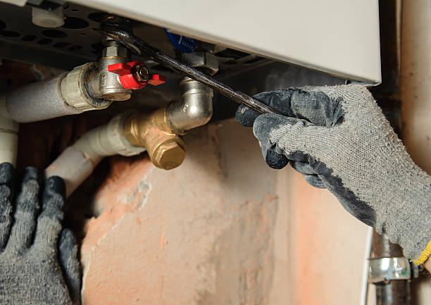 istock Two gloved hands using wrench to connect a gas boiler 470657568