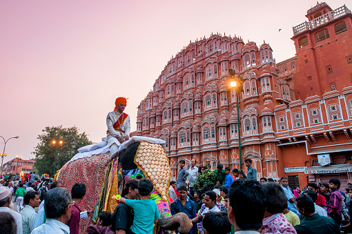 Jaipur, India - November 4, 2014: A fully dressed elephant in a parade which is part of a local Muslim festival. The background is the landmark of Jaipur, Hawa Mahal.