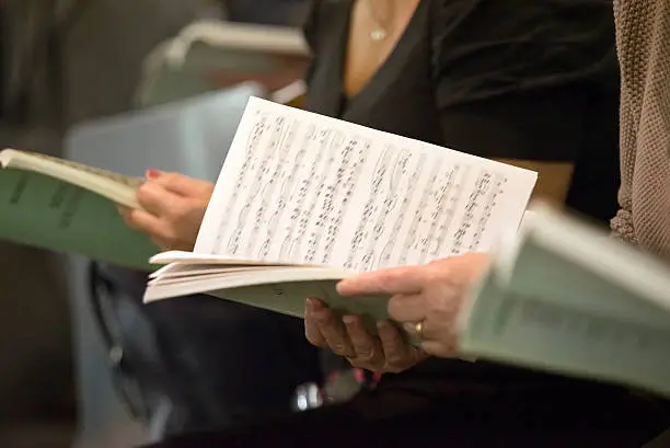 Choir singers female hands holding musical scores