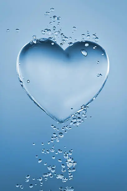 Heart made of water surrounded by bubbles on blue gradient background.