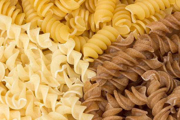 Fusilli pasta close up Three types of uncooked fusilli pasta. carbohydrate food type photos stock pictures, royalty-free photos & images