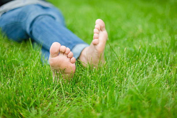 istock Child's bare feet in green grass 470668253