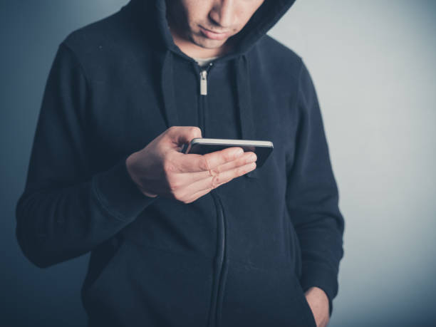 istock Man in hooded top using his smartphone 470669422