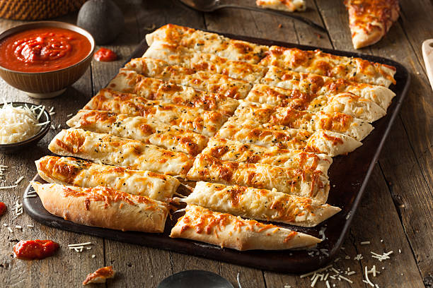 Homemade Cheesy Breadsticks with Marinara Homemade Cheesy Breadsticks with Marinara Sauce for Dipping breadstick stock pictures, royalty-free photos & images