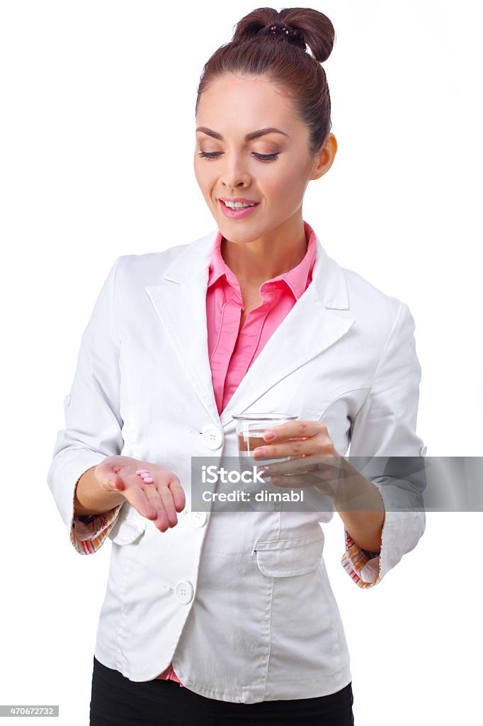 Medicines in hand of doctor Women doctor holding medicine in hand and glass of water.  All isolated on white background. 2015 Stock Photo