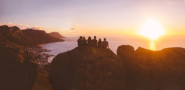Panoramic view of silhouetted hipster watching the sunset over sea