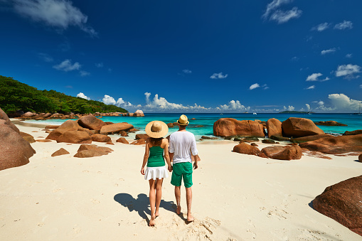 Pareja en verde caminando por una playa, en Seychelles photo