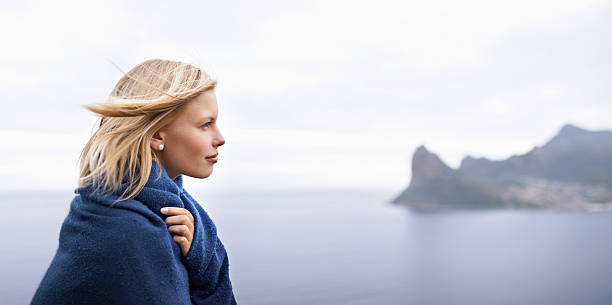 Shot of a beautiful young woman standing at the ocean