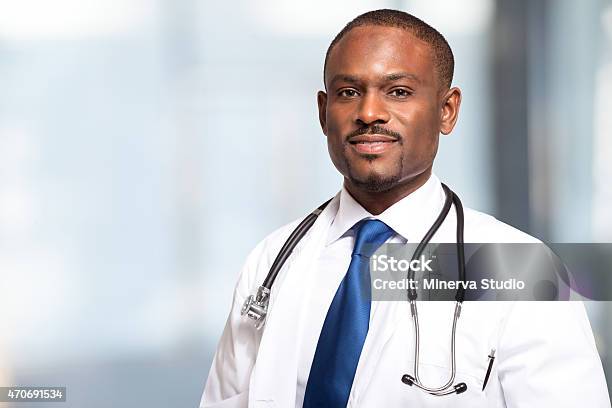 Portrait Of A Smiling African American Male Doctor Stock Photo - Download Image Now - Blue, Doctor, 2015