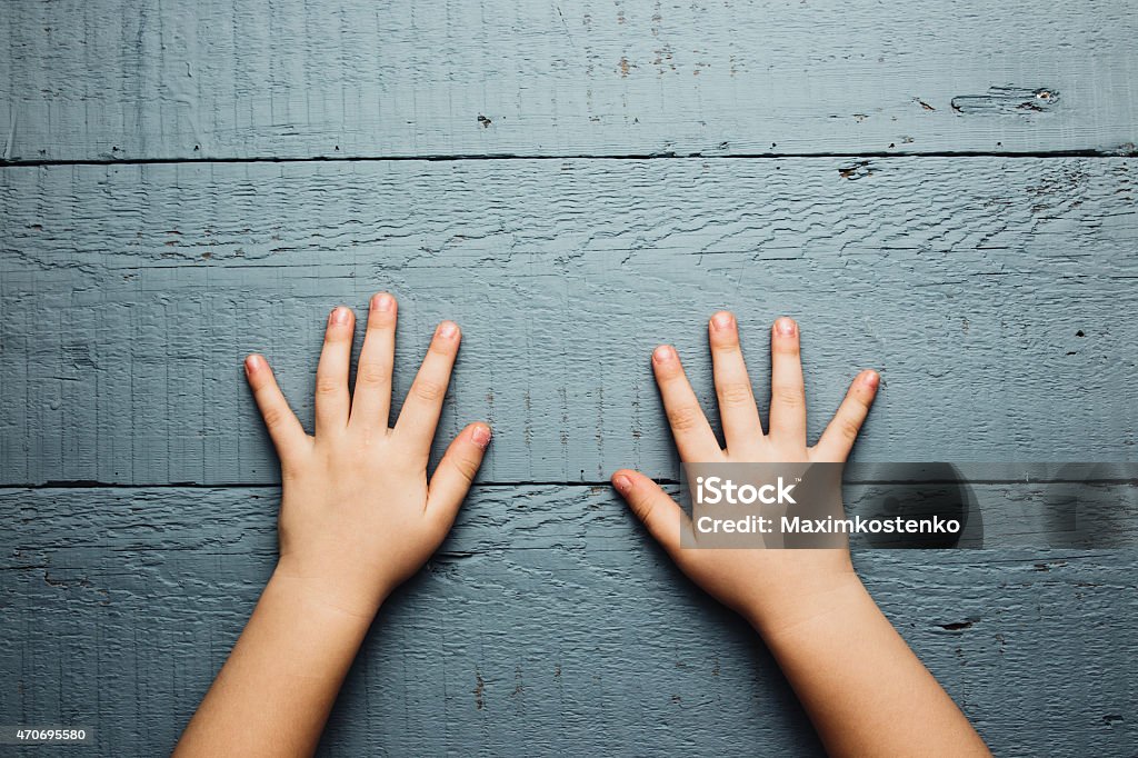 Children's hands is located on an old wooden plate 2015 Stock Photo