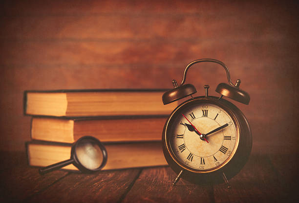 istock Books with loupe and retro alarm clock 470696130
