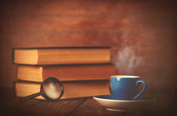 istock Cup of coffee and book with loupe 470696194