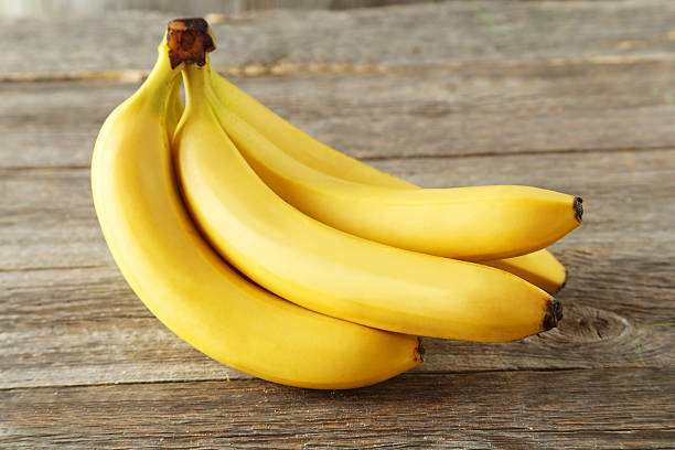 istock Bunch of bananas on grey wooden background 470696878