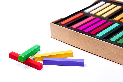 Close up view of the colorful chalk pastels and box on the white background.