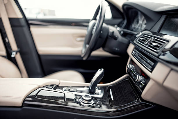 Modern Automatic transmission and gear stick, steering wheel and dashboard Modern beige and black interior of modern car, close-up details of automatic transmission and gear stick against steering wheel background and dashboard car interior stock pictures, royalty-free photos & images